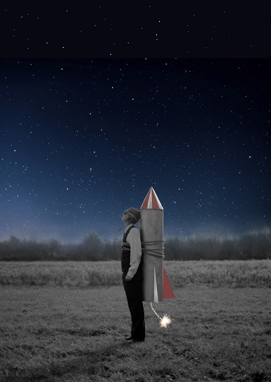 Person mit umgeschnallter Rakete schaut gen Nachthimmel